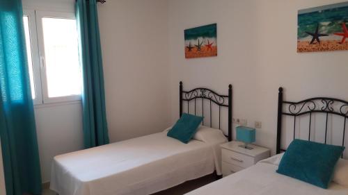 a bedroom with two beds and a window at Duplex Atlan II in Caleta De Fuste
