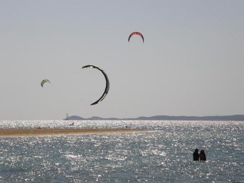 two people standing on a beach flying kites at Anna Platanou Suites in Agia Irini Paros