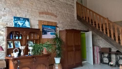 a living room with a wooden cabinet and a staircase at La ferme du Grand Faubourg in Pont-de-Vaux