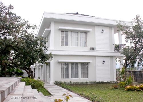 a white house with a tree in front of it at Sevilla Resort Magelang in Magelang
