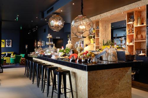 un bar en un restaurante con taburetes en Hotel Friends en Colonia