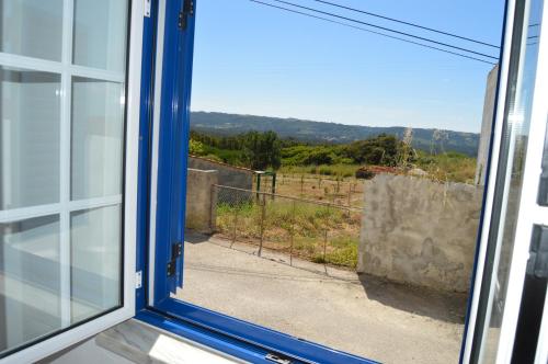 ein offenes Fenster mit Blick auf ein Feld in der Unterkunft Alojamentos dos Mangues in São Martinho do Porto