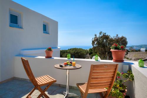 a small table and two chairs on a balcony at Villa Aegeon in Megalokhori
