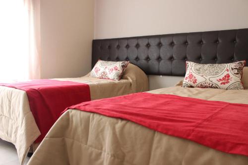 a bedroom with two beds and a headboard at Kitek Hotel Boutique in Mendoza