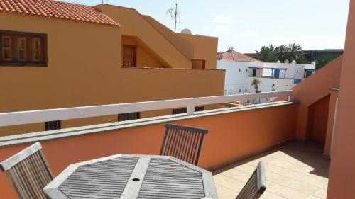 a balcony with a table and chairs on a building at Duplex Atlan II in Caleta De Fuste