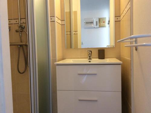 une salle de bain avec un lavabo blanc et un miroir dans l'établissement Appartement - Ile des pecheurs, au Cap d'Agde