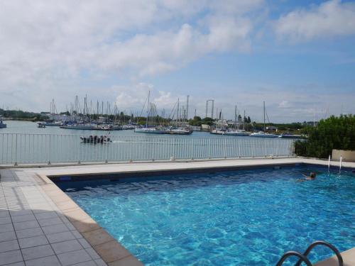 une grande piscine à côté d'un port de plaisance avec des bateaux dans l'établissement Appartement - Ile des pecheurs, au Cap d'Agde