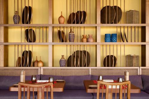a restaurant with two tables and vases on the wall at Kerry Hotel Hong Kong by Shangri-la in Hong Kong