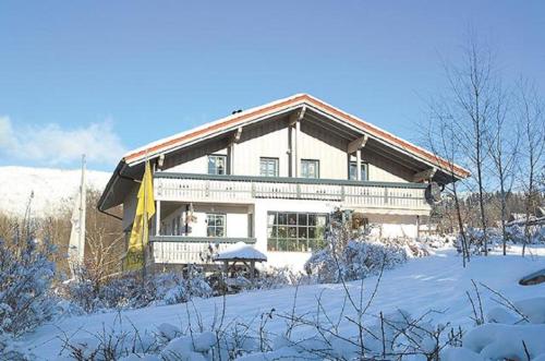 ein großes Haus mit Schnee auf dem Boden in der Unterkunft Ferienwohnung Breu in Arnbruck