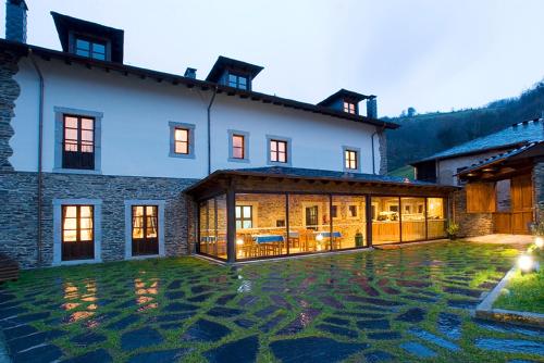 a large house with a courtyard in front of it at Hotel y apartamentos rurales L'Anceo in Cibuyo