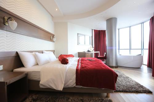 a bedroom with a large bed and a bath tub at City Palace Hotel in Ohrid