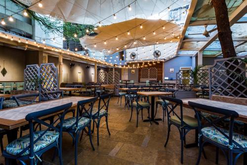 a restaurant with wooden tables and chairs at Le Sutra Hotel, Khar, Mumbai in Mumbai