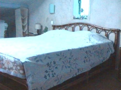 Una cama con una colcha blanca con flores. en Appartement Soleyade, en Vedène