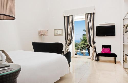 a bedroom with a bed and a window with a view of the ocean at Villa Marina Capri Hotel & Spa in Capri