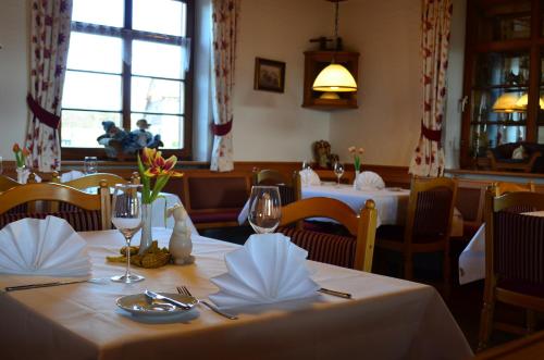 a dining room with two tables with white tablecloths at Hotel Landgasthof Kranz in Hüfingen