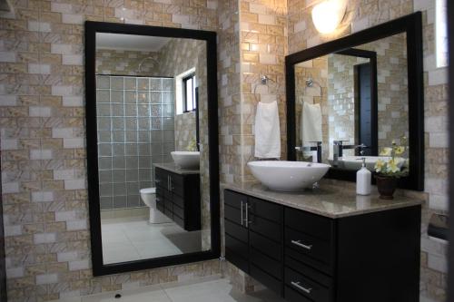 a bathroom with a sink and a mirror at Surfers Cove Apartments in Bel Ombre