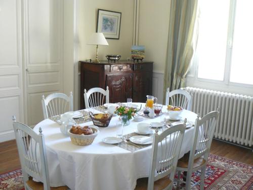 a white table with white chairs and a table with food on it at La Maison de Saumur in Saumur
