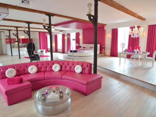 a living room with a pink couch and a table at Cozy Stay with Pool & Nature in Ensival