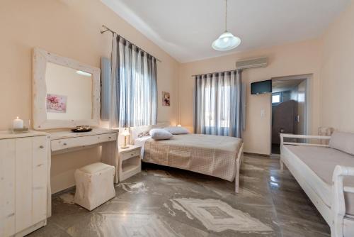 a bedroom with a bed and a sink and a mirror at Villa Aegeon in Megalokhori