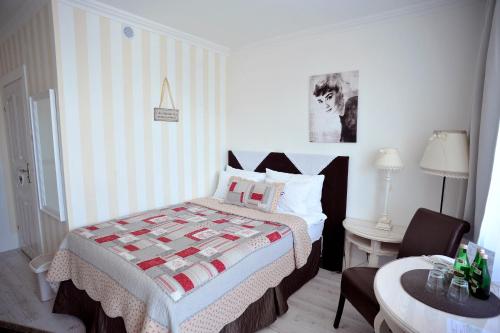a bedroom with a bed and a table and a chair at Hotel Ottaviano in Świnoujście