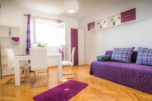 a living room with a purple couch and a table at Apartments Kike&Ana in Split