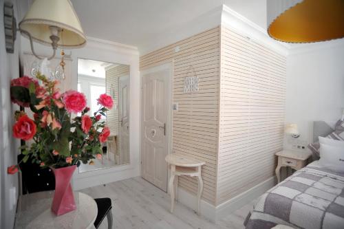 a bedroom with a bed and a vase of flowers at Hotel Ottaviano in Świnoujście