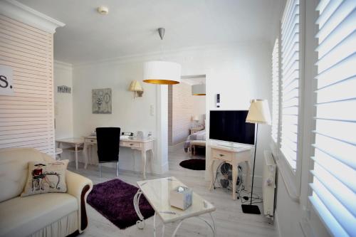 a white living room with a couch and a table at Hotel Ottaviano in Świnoujście