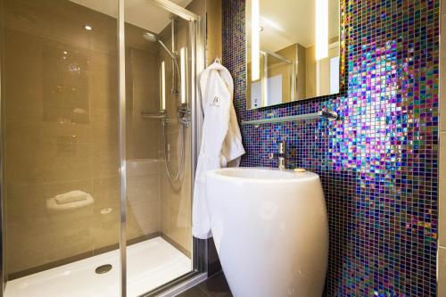 a bathroom with a shower and a toilet and a sink at The Belgrave Hotel in London