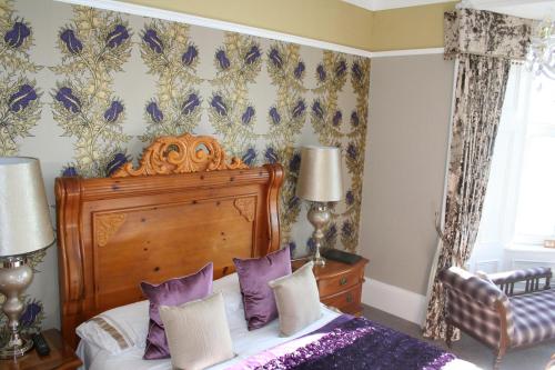 a bedroom with a bed with purple pillows at Altavona House in Oban