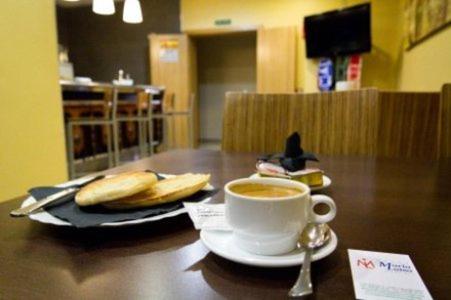 una tazza di caffè seduta su un tavolo con un cucchiaio di Hotel Maria Luisa a Algeciras