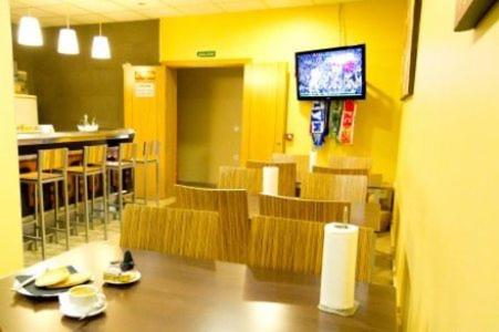 una sala da pranzo con sedie e televisore in un ristorante di Hotel Maria Luisa a Algeciras