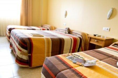 una habitación de hotel con 3 camas en una habitación en Hotel Maria Luisa en Algeciras