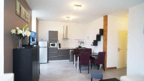 une cuisine et une salle à manger avec une table et des chaises dans l'établissement Le Puligny, appartement classé 3 étoiles, à Beaune