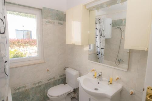 a bathroom with a white toilet and a sink at Apartments Kike&Ana in Split