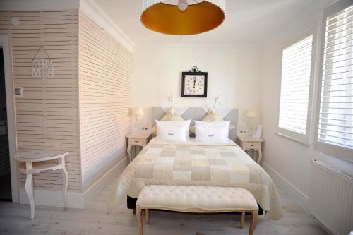 a white bedroom with a bed and two windows at Hotel Ottaviano in Świnoujście