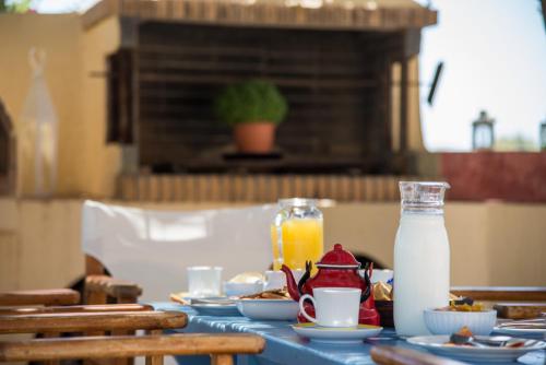 a table with plates of food and a bottle of milk at Asterias Mini Coastal Apartments in Perivolos