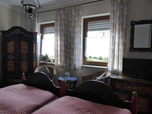 a bedroom with two beds and a tv and a window at Landgasthof Schneller in Katzwinkel