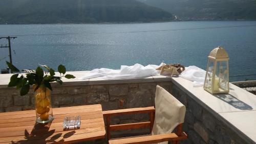 a table with a bench and a view of the water at Εn Plo Luxury Suites in Karavostasion