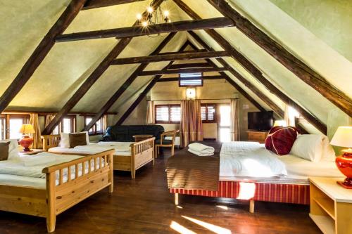 a room with four beds in a room with a roof at Pension U Hada in Český Krumlov