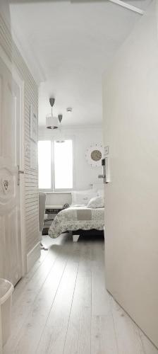 a white room with a bed and a window at Hotel Ottaviano in Świnoujście