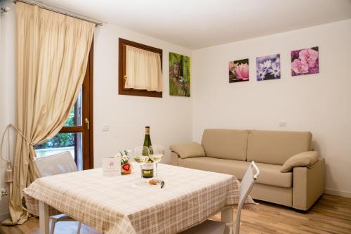 a living room with a table and a couch at Residence Rta La Rosa delle Dolomiti in Carisolo
