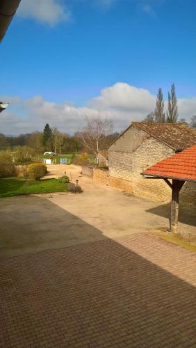 a brick walk way with a building and a bench at La ferme du Grand Faubourg in Pont-de-Vaux