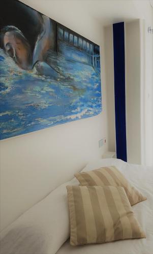a painting hanging on a wall above a bed at San Giorgio Modica Hotel in Modica
