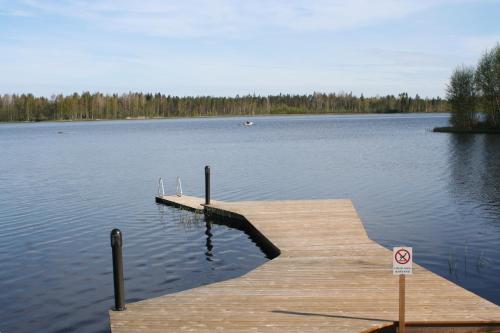 a dock on a lake with a no swimming sign at Haarusmaa Holiday Apartment Härmä in Härmä
