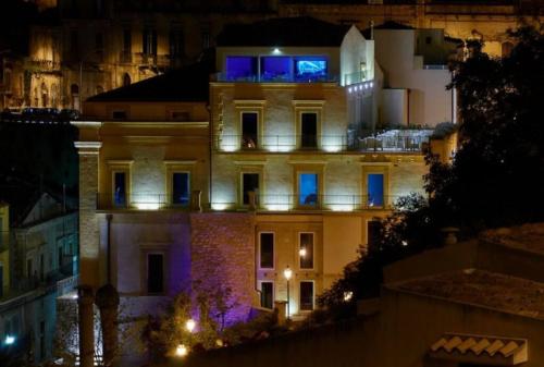 a large building with a large clock on the top of it at San Giorgio Modica Hotel in Modica