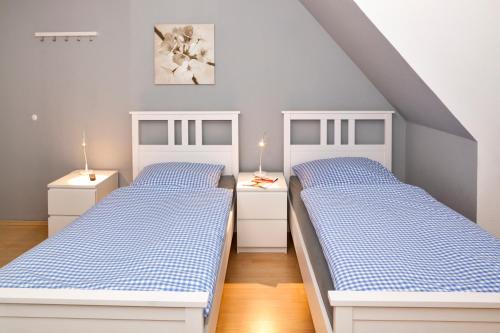 two beds in a bedroom with blue and white at Bett4-you Pinneberg - Prisdorf in Prisdorf
