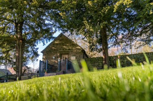 a building in the middle of a field of grass at The Piggery in Longton