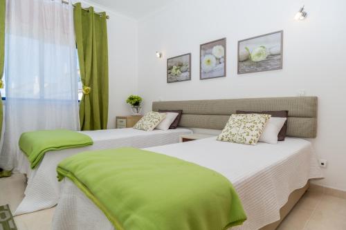 フェラグドにあるAkisol Portimao Vale IIの緑のカーテンが備わる客室のベッド2台