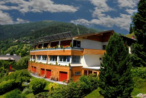 a building with a balcony with flowers on it at Das Sonnenheim in Bad Kleinkirchheim