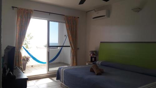 a bedroom with a bed and a large sliding glass door at Hotel Casa Chacala in Chacala